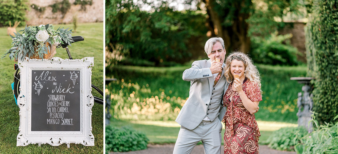 A decorative chalkboard sign with ice cream flavours stands beside a bicycle; next to it, a smiling man in a suit and a woman in a patterned dress enjoy ice cream cones outdoors in a lush, sunny garden.