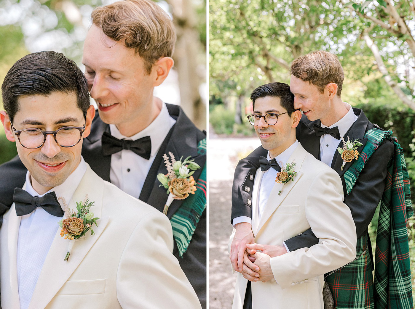 Two grooms embrace outdoors: one in a white dinner jacket with glasses, the other in a black dinner suit with a green tartan sash. They smile affectionately, surrounded by greenery in natural daylight.